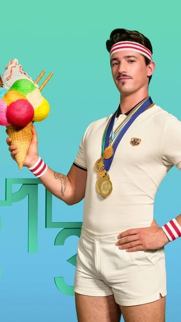 Athletic-looking man in retro tennis attire holding large ice cream cone with award medals around his neck against blue background.