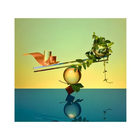 Abstract still life with floating geometric shapes, green vines, and glass spheres against a split yellow and blue background. Modern, minimal.