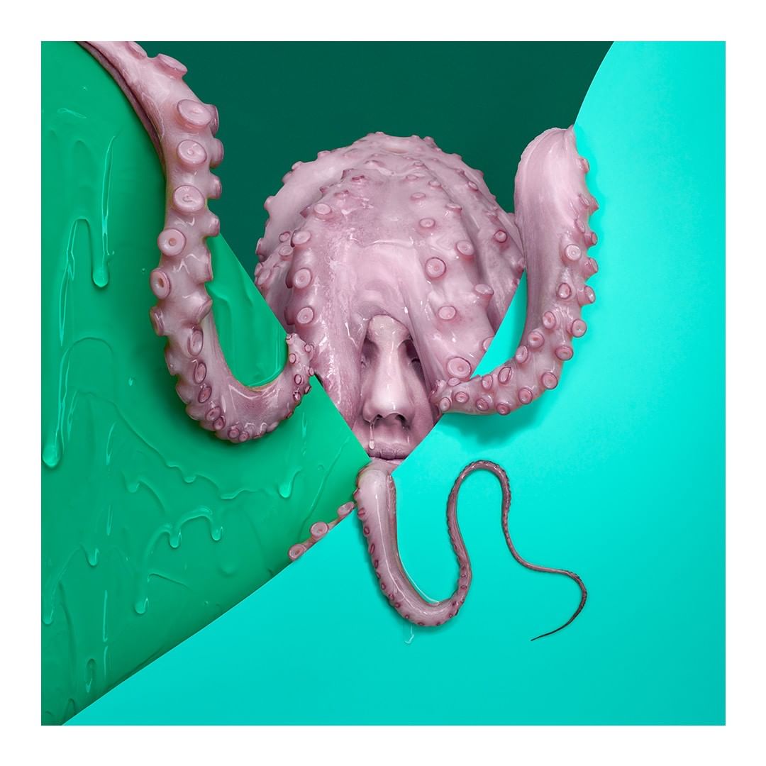 Surreal illustration featuring an octopus with a human face, set against a divided background of green and teal. The image blends textures and forms.