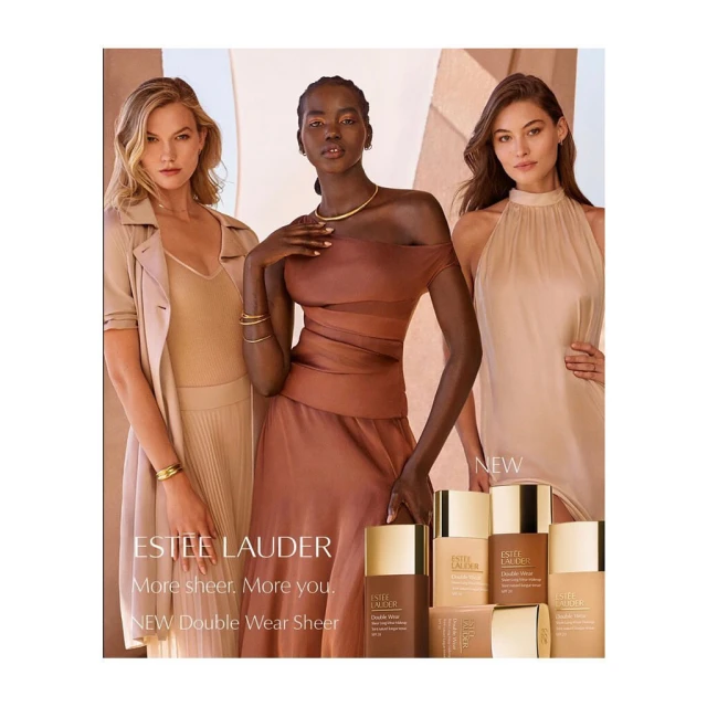 Three women pose in Estee Lauder Double Wear Sheer makeup advertisement, showcasing a collection of foundation bottles in various shades.
