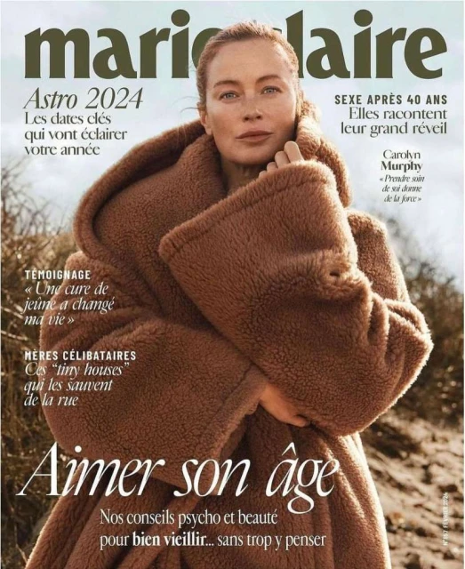 Magazine cover featuring an adult woman with red hair wearing a brown coat against a blurred outdoor background, with magazine text.