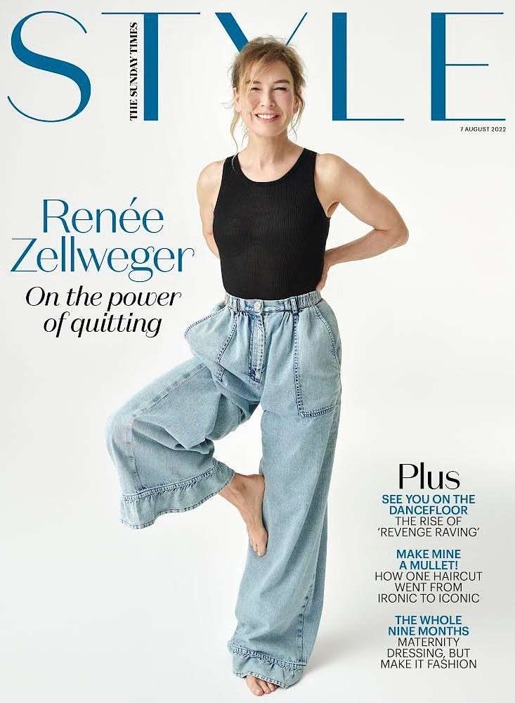Magazine cover featuring Renée Zellweger in a black top and light blue jeans, standing barefoot in a unique pose with the magazine's title.