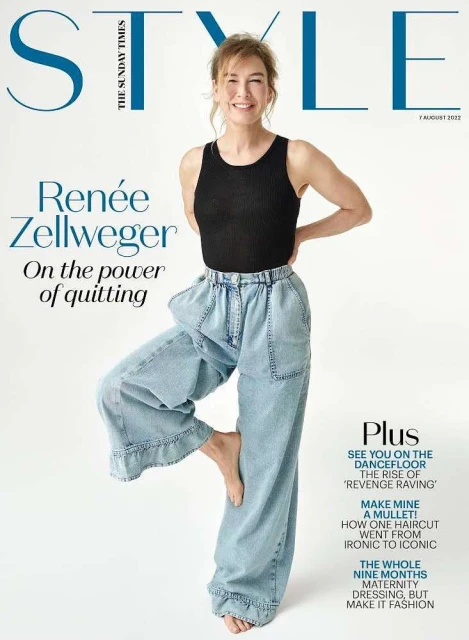 Magazine cover featuring Renée Zellweger in a black top and light blue jeans, standing barefoot in a unique pose with the magazine's title.