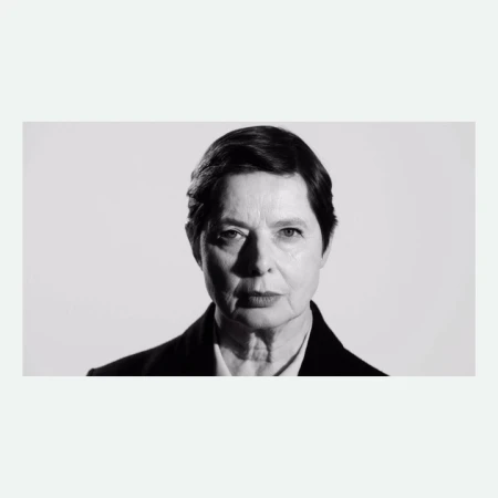 Portrait of an older woman with short dark hair in a black blazer against a plain white background by Paola Kudacki