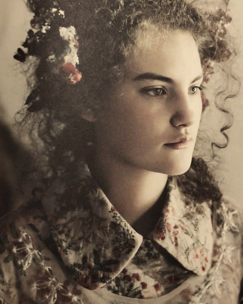 Portrait of a woman with curly hair wearing a patterned floral collar shirt by photographer Paolo Roversi.