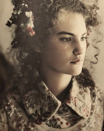 Portrait of a woman with curly hair wearing a patterned floral collar shirt by photographer Paolo Roversi.