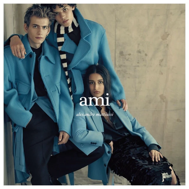 Three fashion models showcase teal coats and black attire against a neutral backdrop. Fashion-forward outerwear and chic styling.