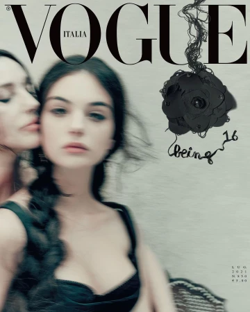 Vogue Italia cover featuring two young women with dark hair in black tops, one embracing the other with a shallow depth of field.