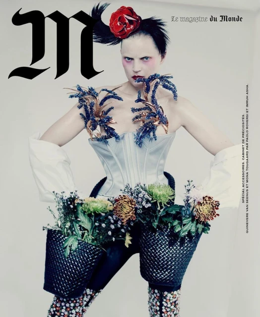 Magazine cover featuring a model with elaborate floral and textile adornments, showcasing avant-garde fashion and creative styling.