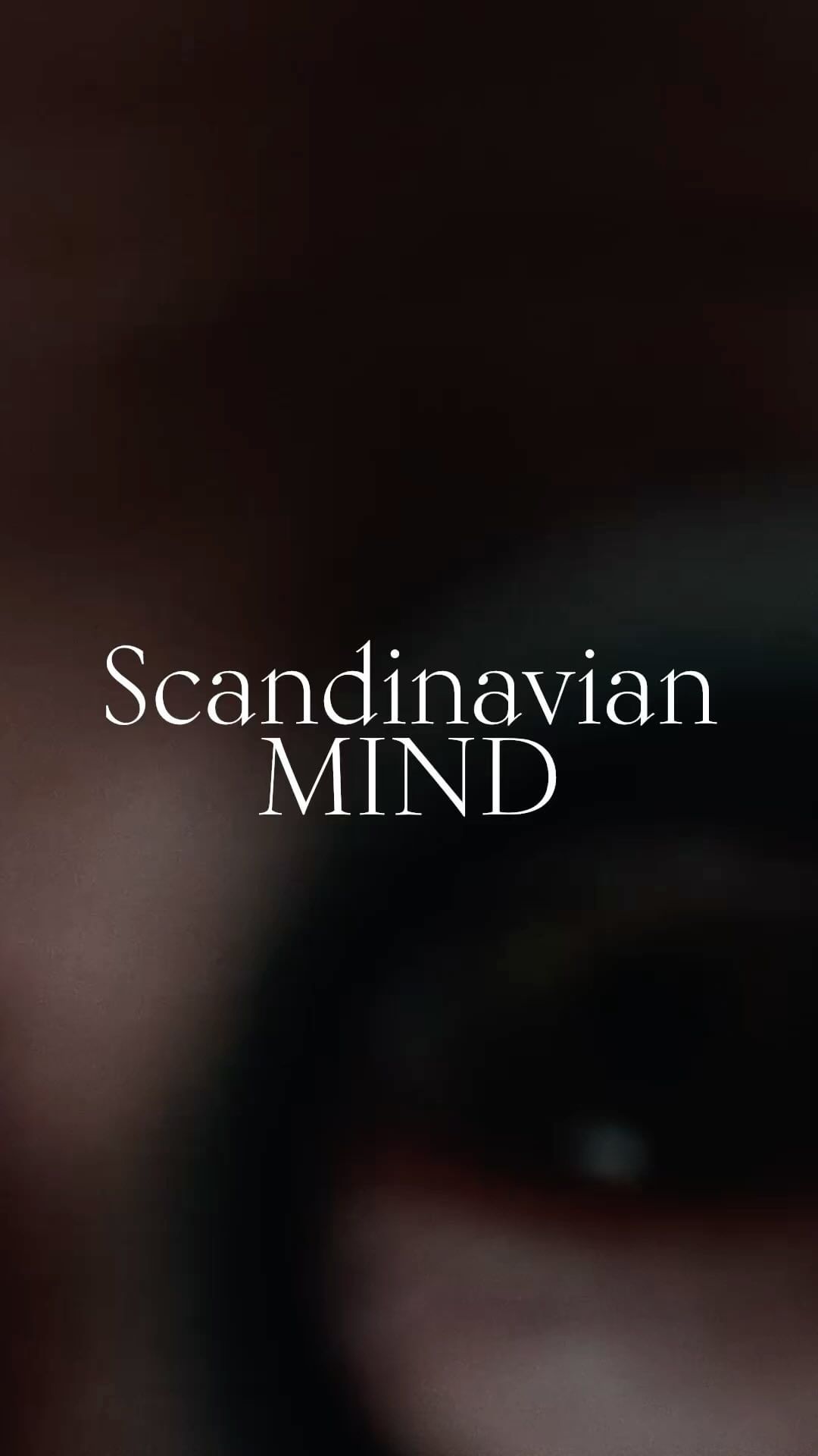 Close up vertical image of an eye with the text 'Scandinavian MIND' overlaid on it. The background is dark and blurry.