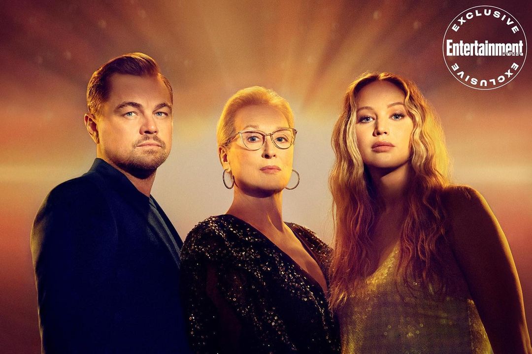 Promotional image featuring actors Leonardo DiCaprio, Meryl Streep, and Jennifer Lawrence, from the movie Don't Look Up, against orange backdrop.