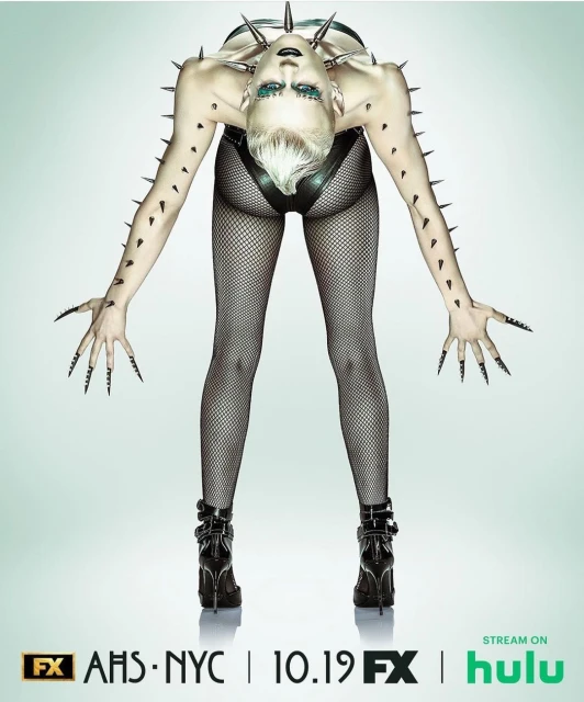 Promotional image for American Horror Story: NYC features a human with long black nails wearing a spiked collar and high-heeled boots.