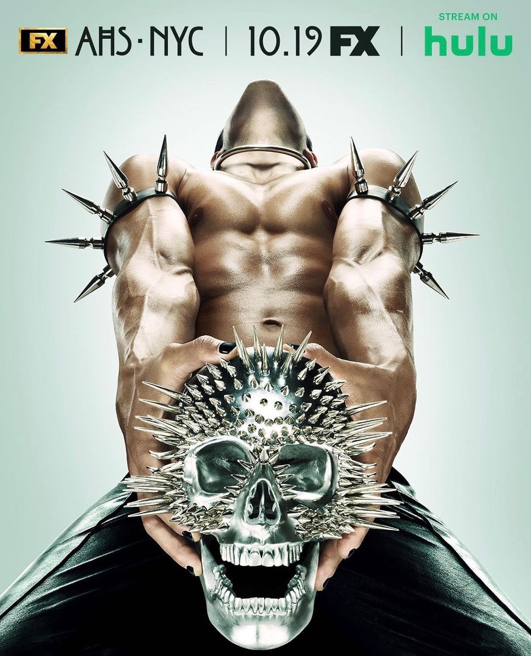 American Horror Story NYC poster featuring a shirtless bodybuilder with spikes, holding a spiked skull mask, advertising the show.