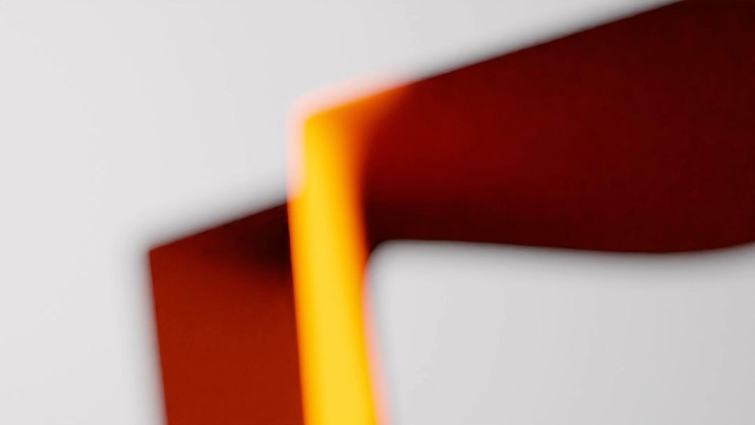 Abstract design featuring blurred shapes in shades of white, orange, and red, creating a visually dynamic background pattern.