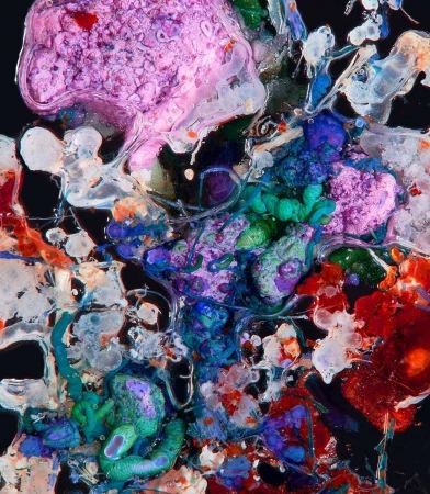 Abstract multicolored fluid art background with pink, blue, green, and red organic shapes against a dark backdrop.