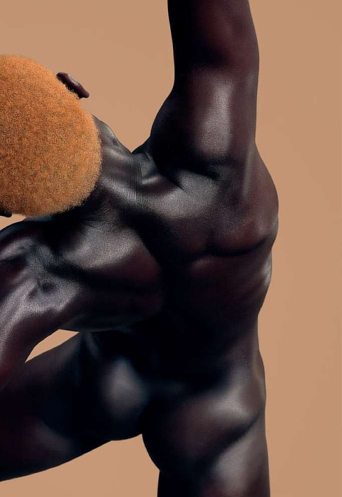 An athletic dark-skinned man with blond afro arches his back in a dynamic pose against a neutral backdrop, showcasing muscular physique.