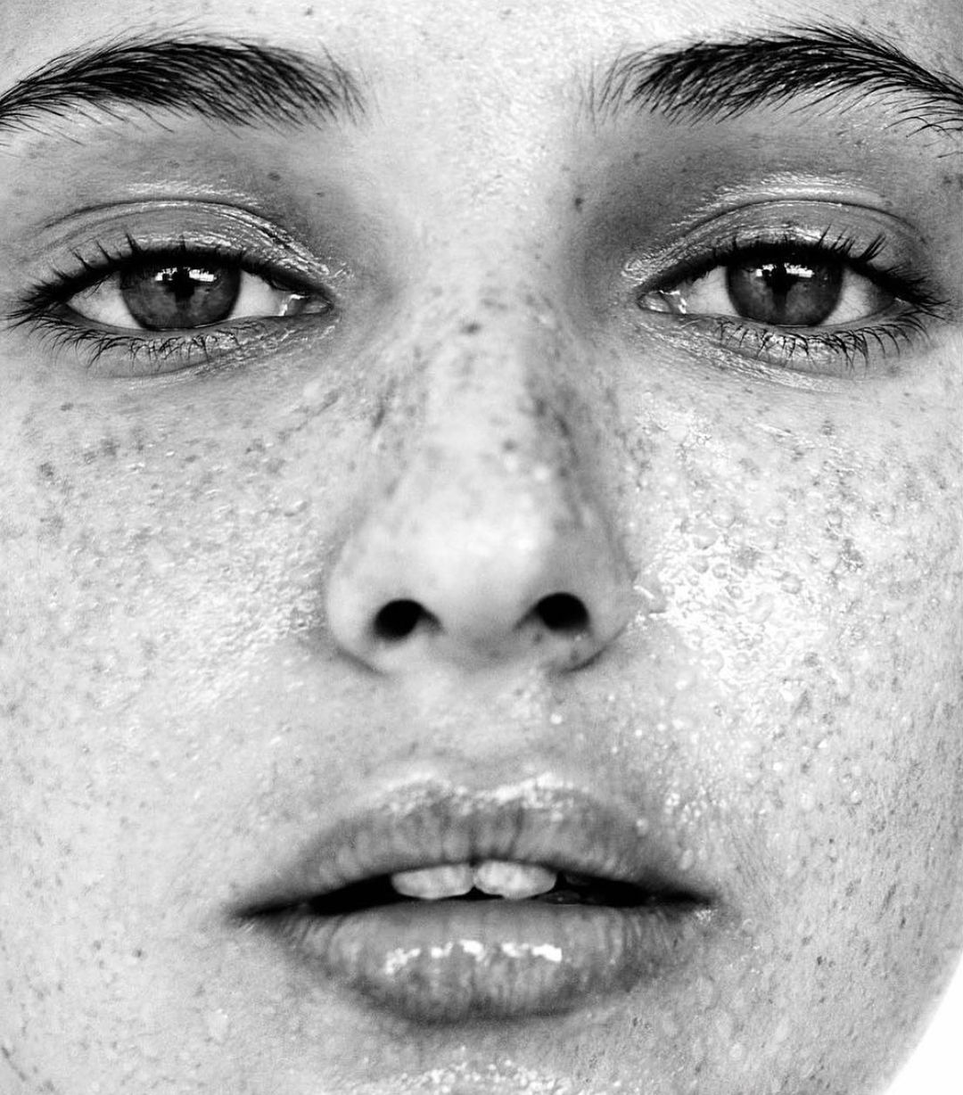 Extreme close-up portrait of a woman face with freckles and dewy skin captured by Patric Shaw in Paris.