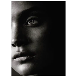 Close-up black and white portrait of a person face with dramatic lighting in a dark setting