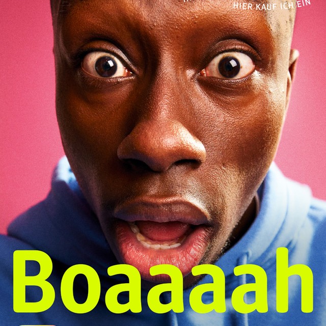 Close-up of an adult male with wide eyes and open mouth, set against a pink backdrop with the text 'Boaaah' visible at the bottom.