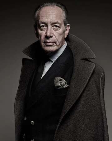 Portrait of an elderly man in a dark suit jacket, collared shirt, tie, and draped wool overcoat by Patrizio Di Renzo
