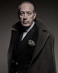 Portrait of an elderly man in a dark suit jacket, collared shirt, tie, and draped wool overcoat by Patrizio Di Renzo
