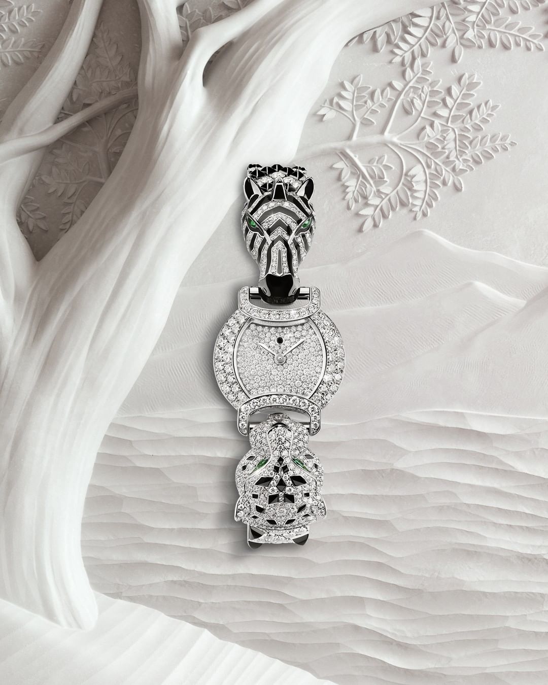 Elegant wrist watch featuring a zebra head, diamonds, and a turtle tail, set against a textured white background that resembles sand dunes.