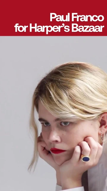 Close-up portrait of a young woman with blonde hair and red lipstick resting her face in her hands, with text above.