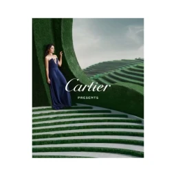 Woman in a long blue evening gown standing against a curved green topiary arch with tiered terraces, photographed by Paul Franco.