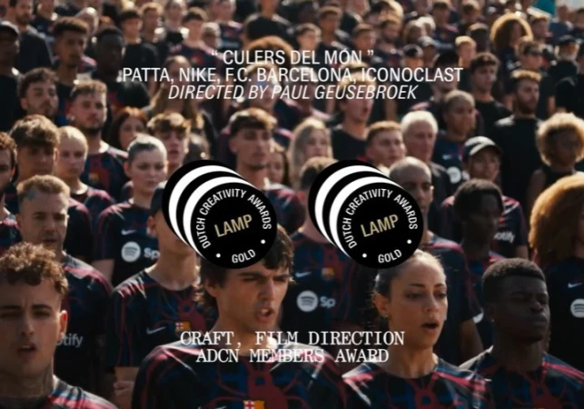 Large crowd of diverse people in Barcelona soccer jerseys, faces visible, looking forward; two awards logos are superimposed in foreground.