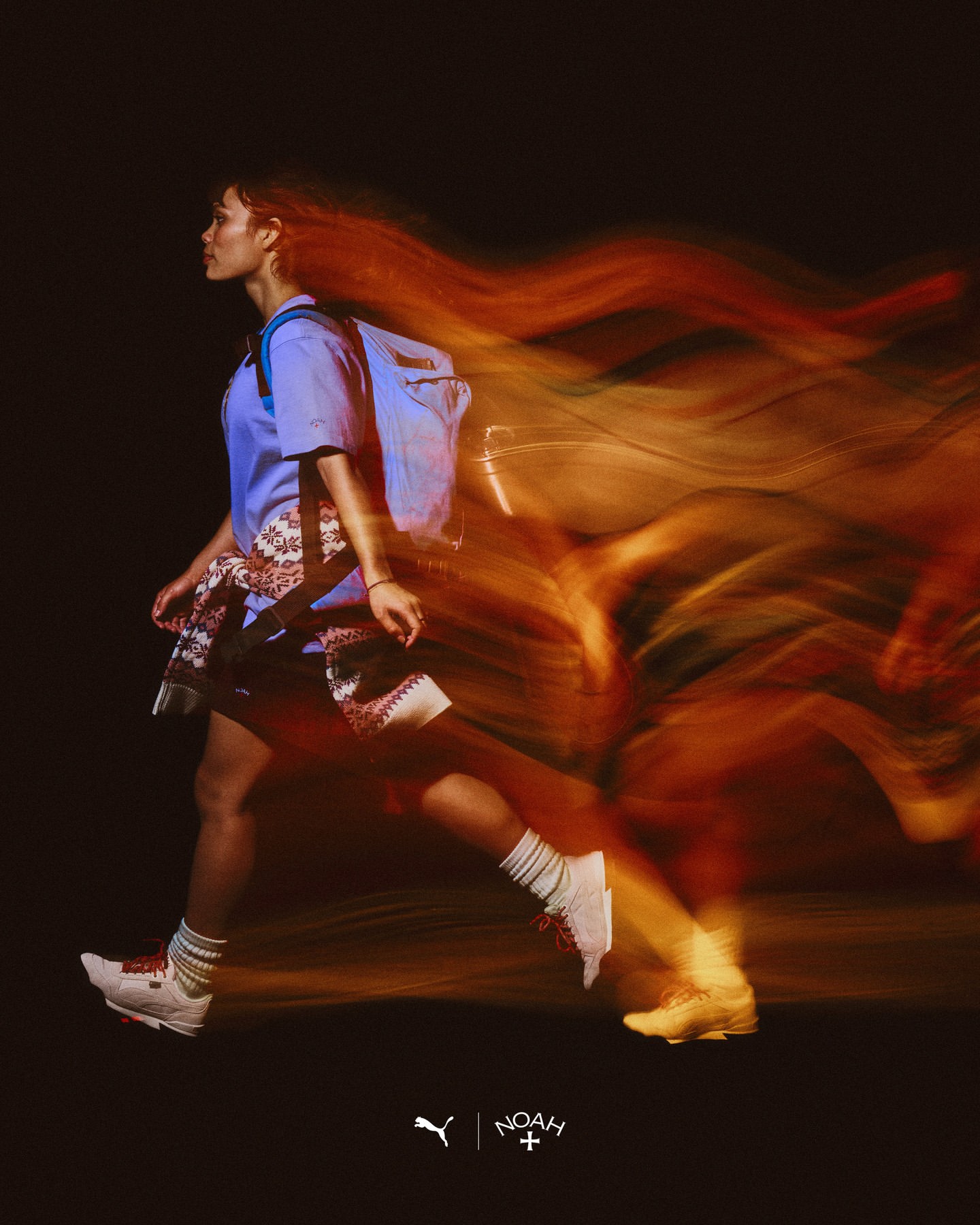 Woman in motion, wearing sneakers, backpack, and summer clothes. Long exposure creates blurred motion effect on a black background.