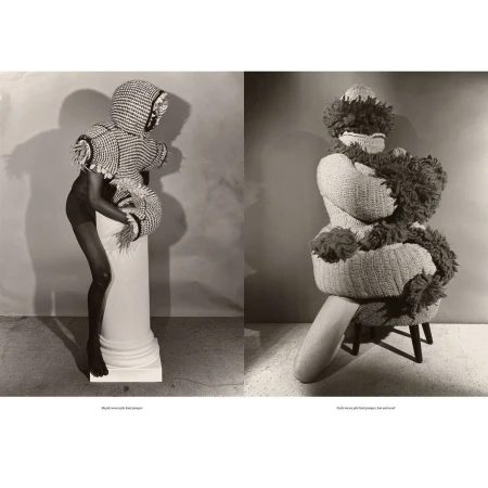 Two figures in unique knitted fashion, one standing on a column, the other seated, in a studio setting with neutral backdrop and soft lighting.
