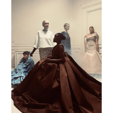 Five fashion models in varied gowns posing within an interior room photographed by Paul Kooiker.