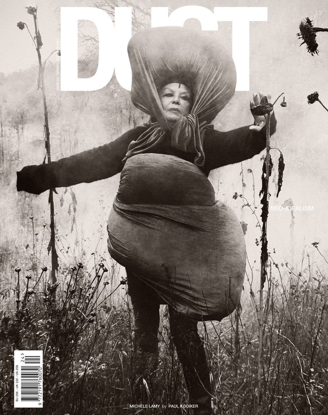 Editorial fashion shot of a woman in field, wearing an oversized fabric garment, with a monochromatic color grade and vintage aesthetic.