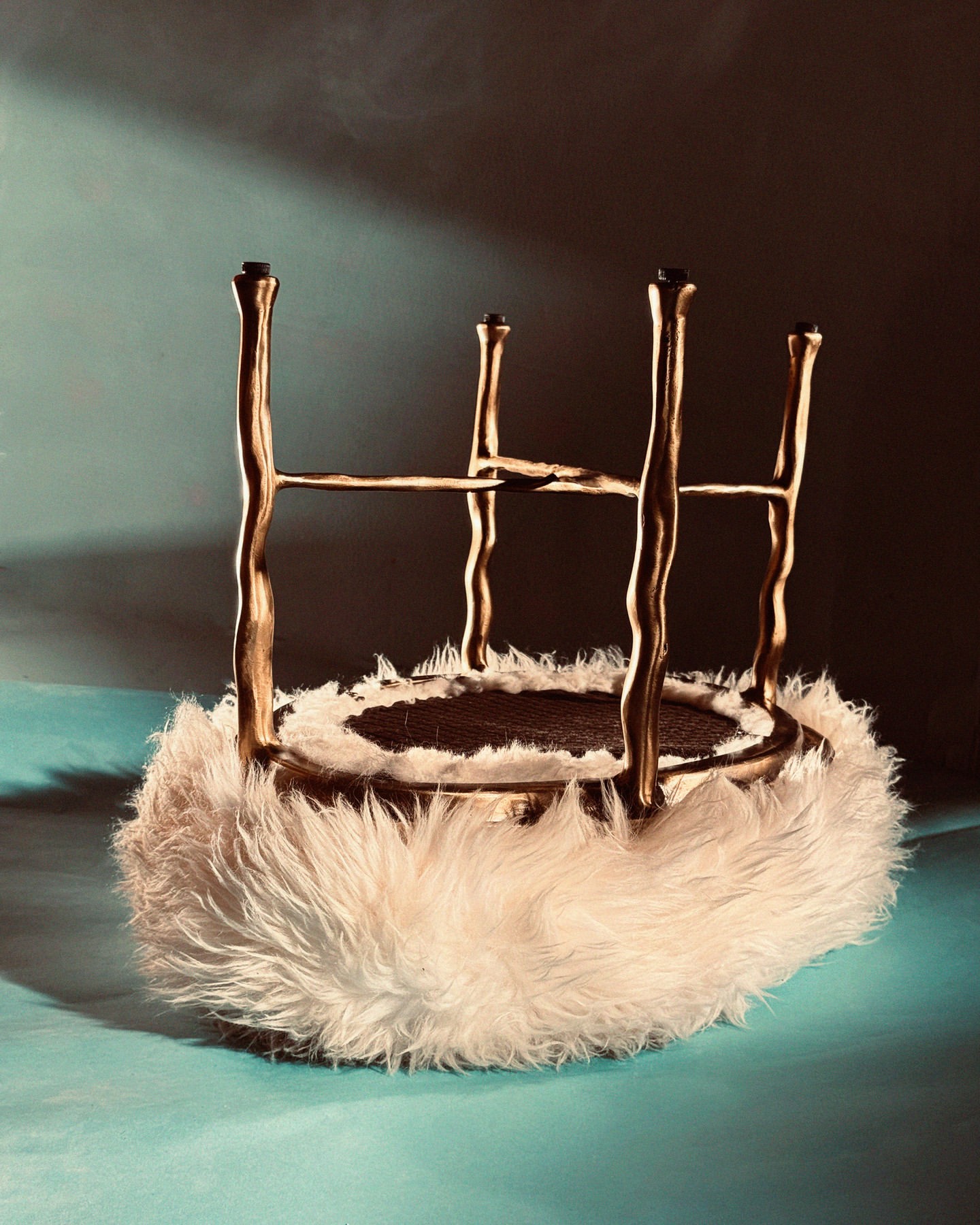 Close-up of a whimsical gold chair with unusual legs and a fluffy white seat, creating a surreal and captivating studio furniture still life.
