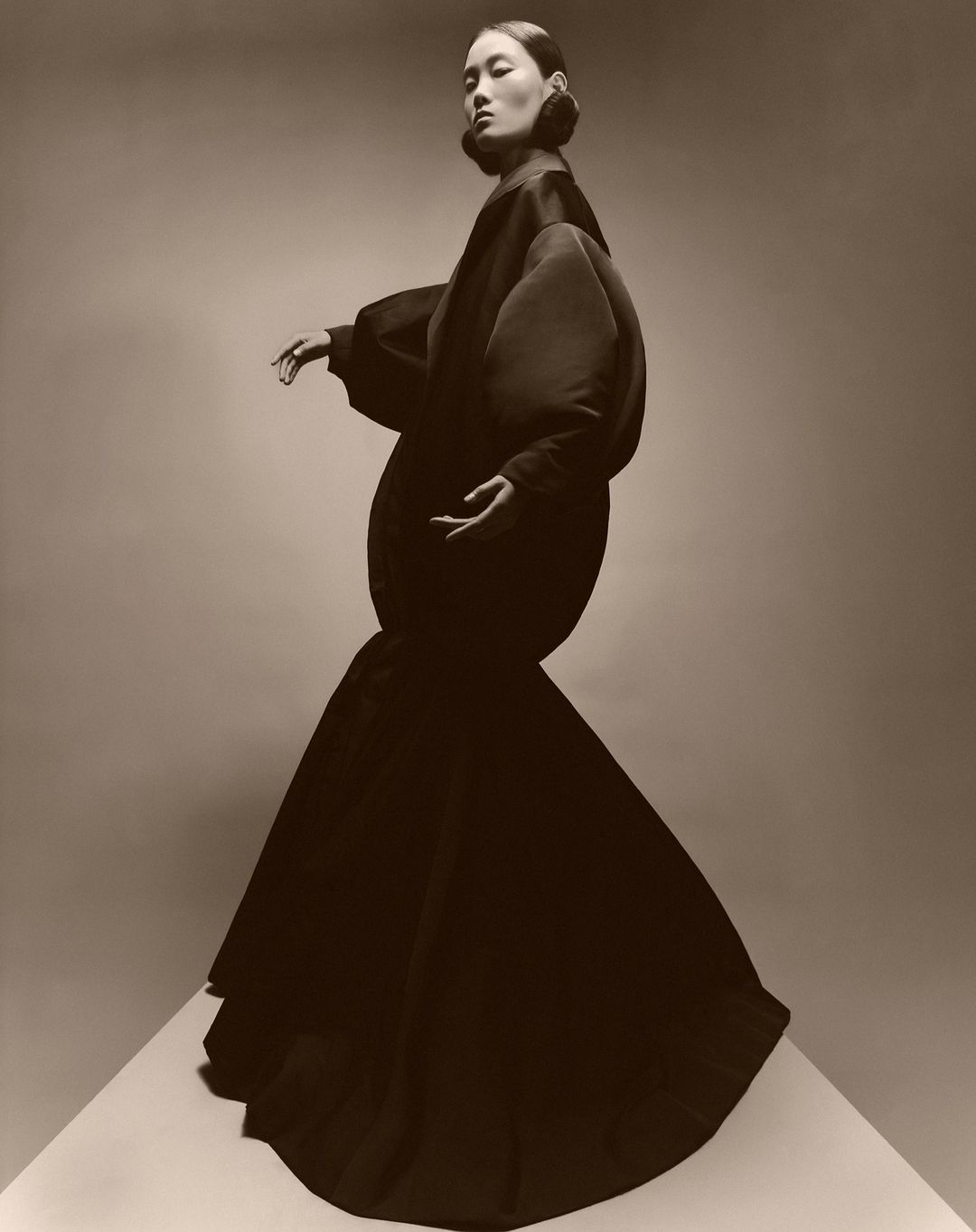 Model wearing a voluminous dark structured gown with distinct rounded silhouette photographed by Paul Kooiker
