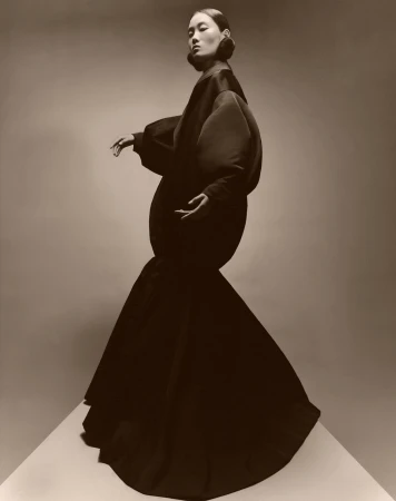Model wearing a voluminous dark structured gown with distinct rounded silhouette photographed by Paul Kooiker