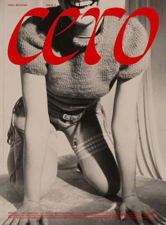 Magazine cover featuring a model kneeling, showcasing a red title, knit sweater, and details of stockings, belt, and a neutral backdrop.