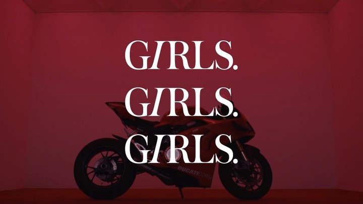 A red sport motorcycle is displayed against a matching red background with the word 'GIRLS' repeated three times in white text.