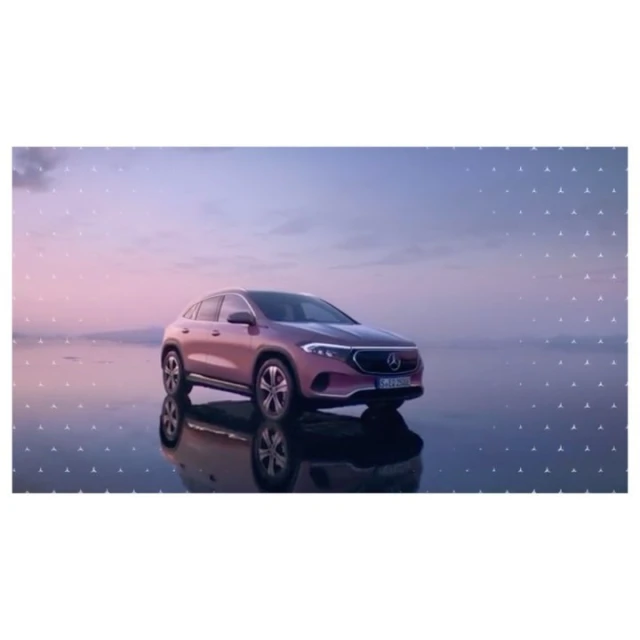 Rose-colored Mercedes-Benz EQB SUV on a reflective surface with soft sunset lighting, set against a sky with subtle cloud formations.