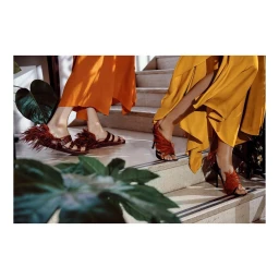 Two women wearing feathered sandals standing on outdoor stone steps in Paris