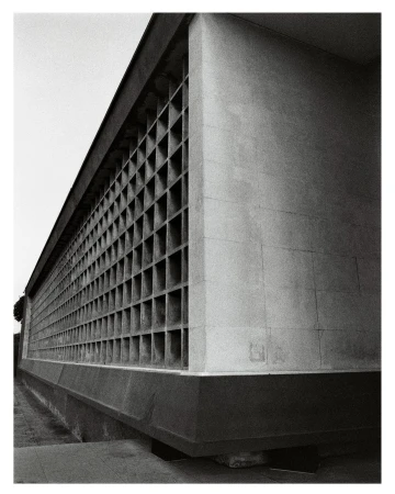 Monochrome architectural photograph showing a brutalist concrete building exterior with a repeating grid facade in Paris.