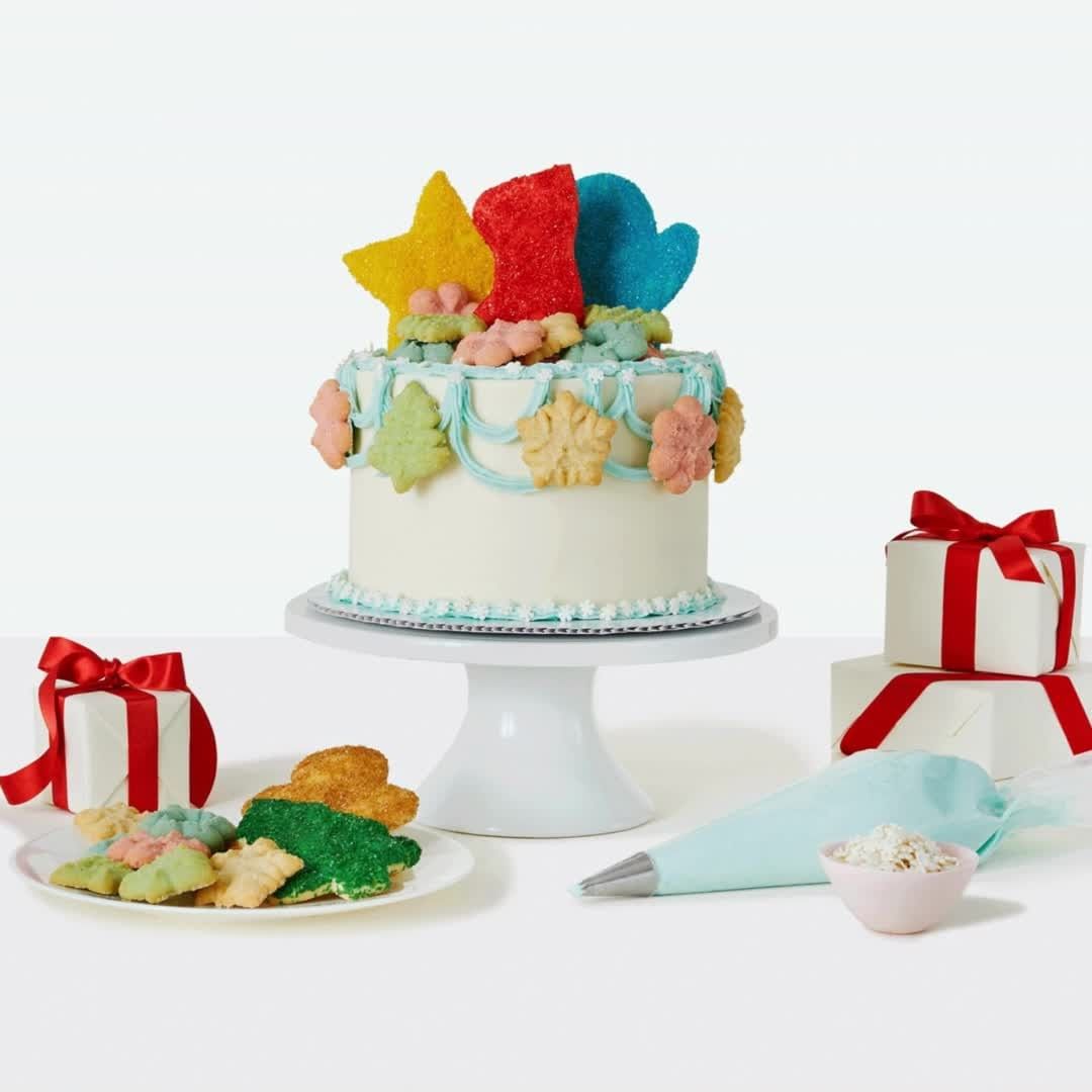 Festive cake with holiday-themed cookies and gifts, set against a clean white background, perfect for celebrations and events.