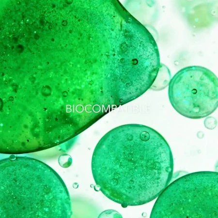 Close-up shot of green liquid and spherical shapes. Abstract image showcases bubbles and vibrant colors against a light background.