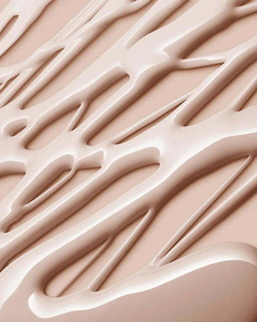 Abstract close-up of beige-toned cosmetic cream or liquid foundation with smooth, glossy texture and diagonal linear patterns.