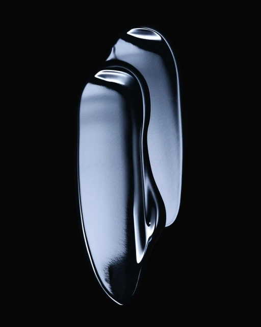 Abstract beauty shot of reflective, textured cosmetic cream in an elongated shape against a solid black studio background, macro photography.