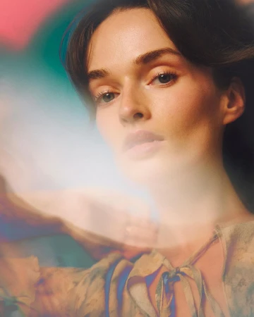 Close-up portrait of a woman with dark hair and soft lighting by photographer Pauline Darley in Paris