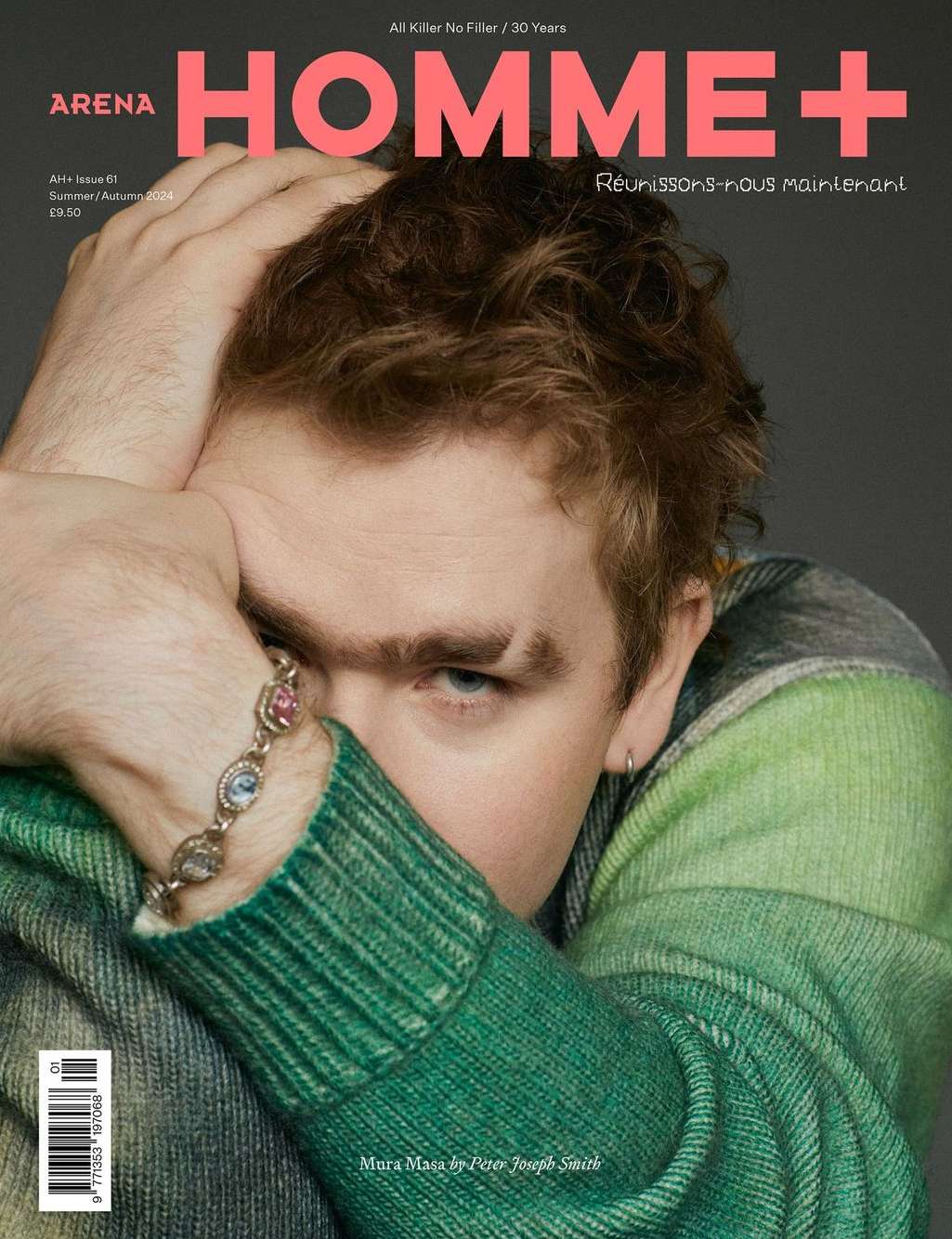 Arena Homme+ magazine cover featuring a young adult male with light skin, red hair, and a bracelet. He poses with his hand on his head.