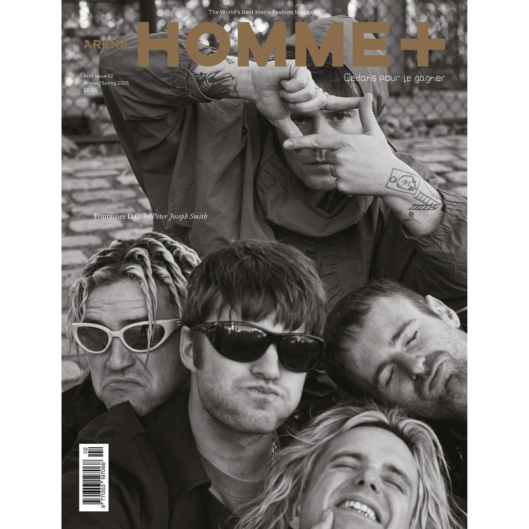 Black-and-white magazine cover featuring five men, with one framing his face with his hands and others clustered below.