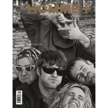 Black-and-white magazine cover featuring five men, with one framing his face with his hands and others clustered below.