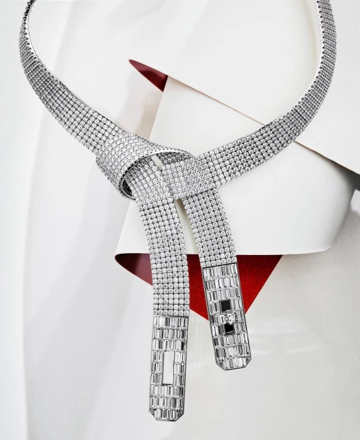 Elegant diamond necklace with tie-knot detail on a white surface with a hint of red creates a striking and luxurious jewelry piece.